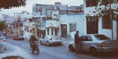 Street scene in Guatemala with cars and a motorcycle in an urban setting