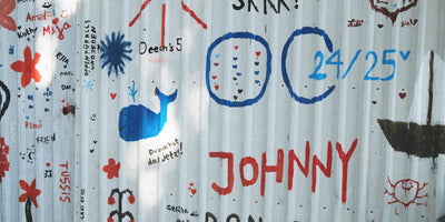 The side of a barn with writing and drawings on it