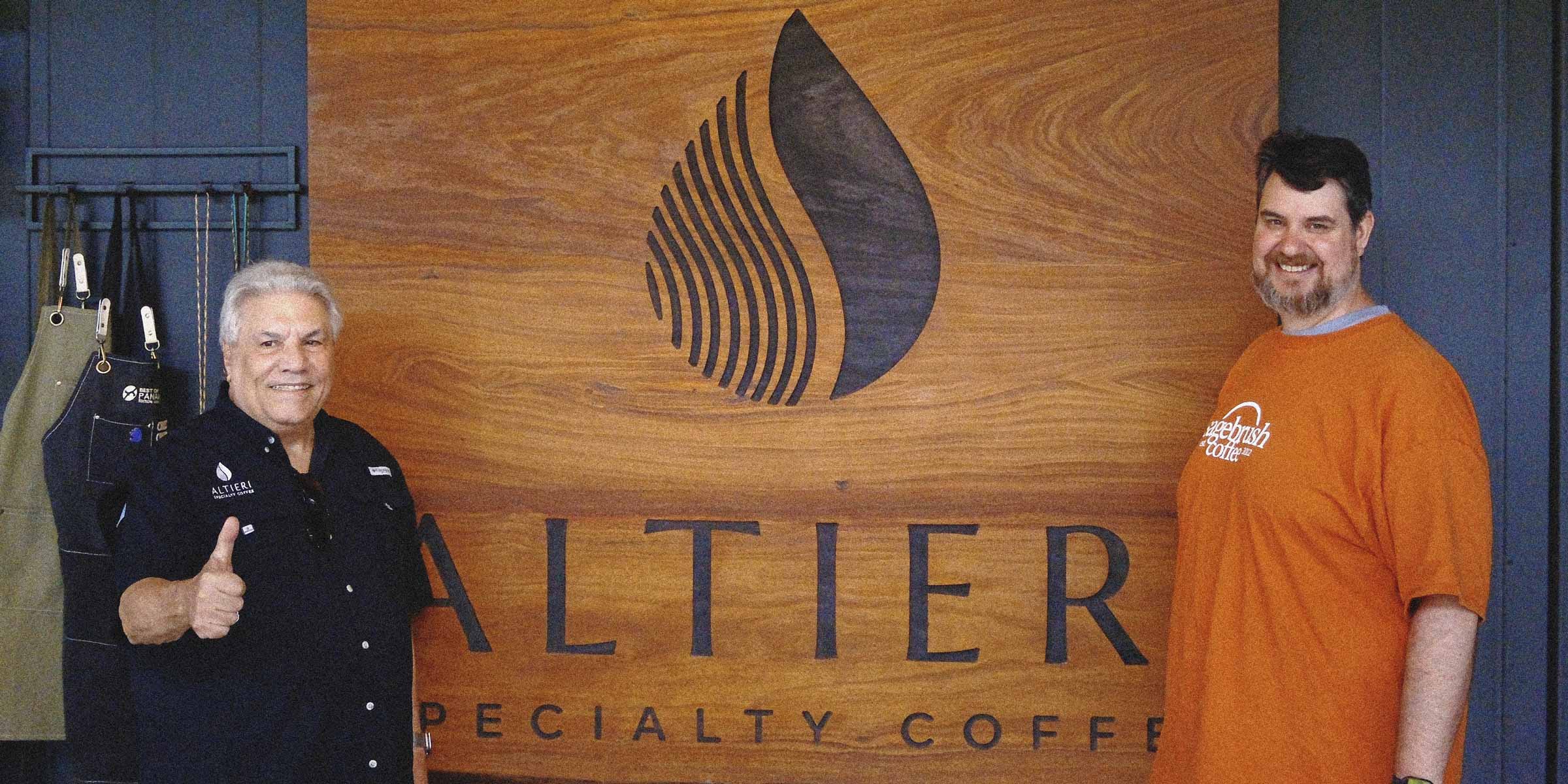 Eugene and Matt posing in front of a wooden sign that says Altieri Specialty Coffee