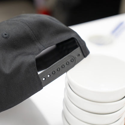 Black cap with a unique design on top of coffee cups